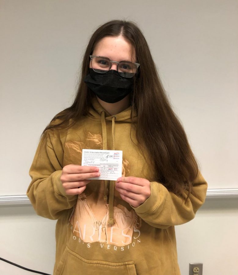 Junior Ashley Cramer poses with her vaccine card. 