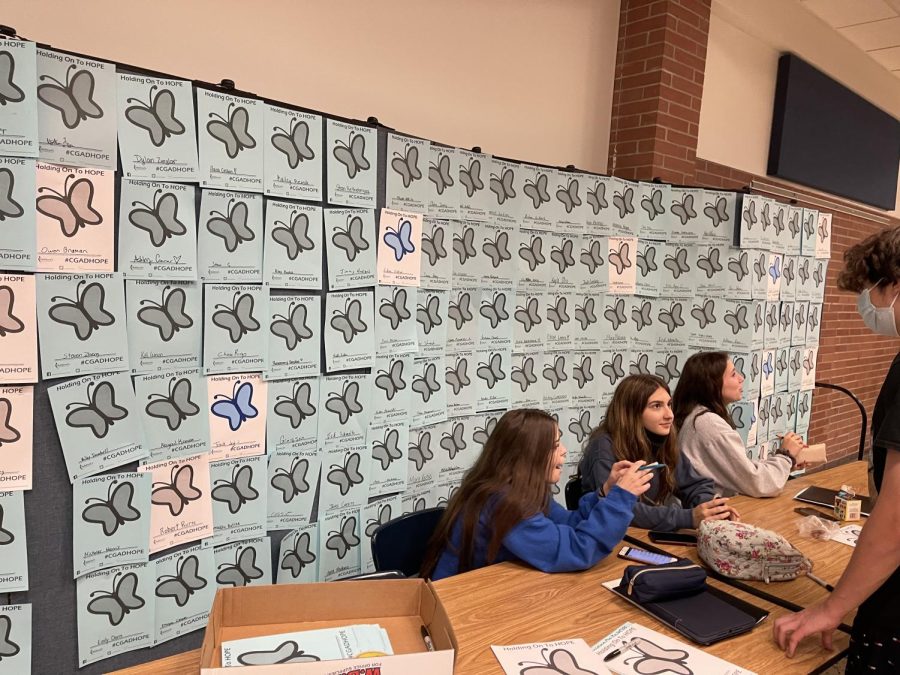 FCCLA members Madison Samber, Maria Janiga, and Kira Walkosak running a table at lunch that helps kids find the resources as well as signing a butterfly to show their support. 
