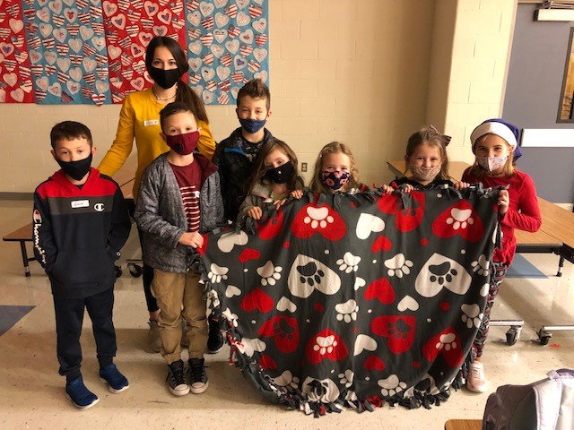 Hahntown students pose with Interact member Kinsey Momeyer with the blankets they made for local nursing home.