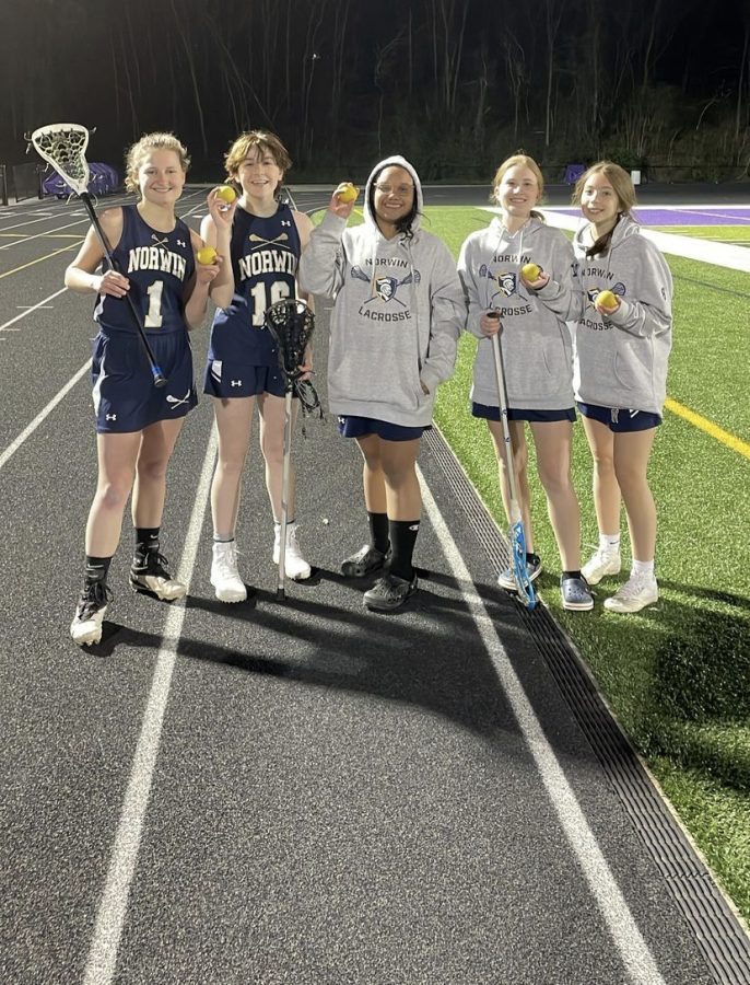 Ashlynn Stephan (12), Ray Mamas (10), Keiarra Leonard (9), Rory Penrose (9), and Liv Migliozzi (9) pose with their MVP balls after a game against Baldwin. 