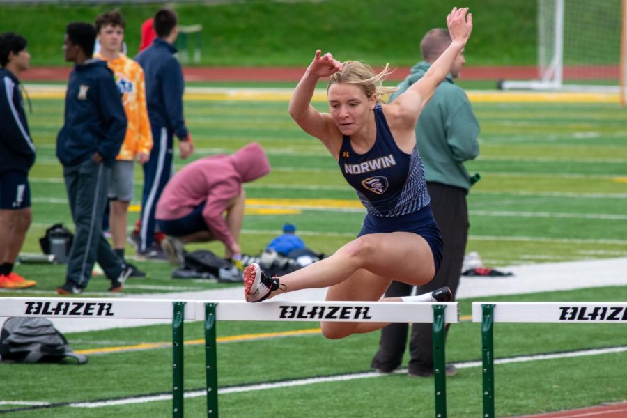 Senior Layla Robertson jumps over a hurdle at Penn-Trafford High School.