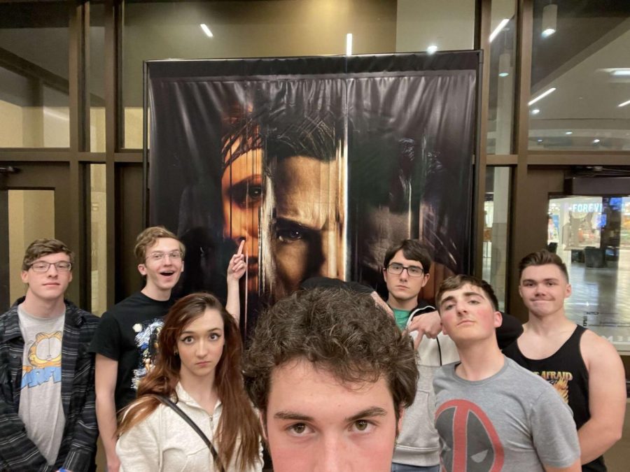 Alex Hunn (12), Evan Blenko (12), Betsy Szymanski (11), Traye Geissler (12), Ryan Fuga (12), Davis Brown (12), and Noah Butler pose in front of a poster for Doctor Strange in the Multiverse of Madness at the Monroeville Mall.