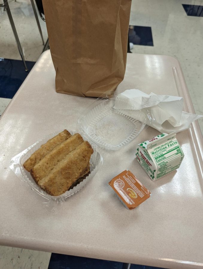 A typical free breakfast, shown here, contains a breakfast entree (french toast sticks and sausage) and a piece of fruit or fruit juice (apple juice).