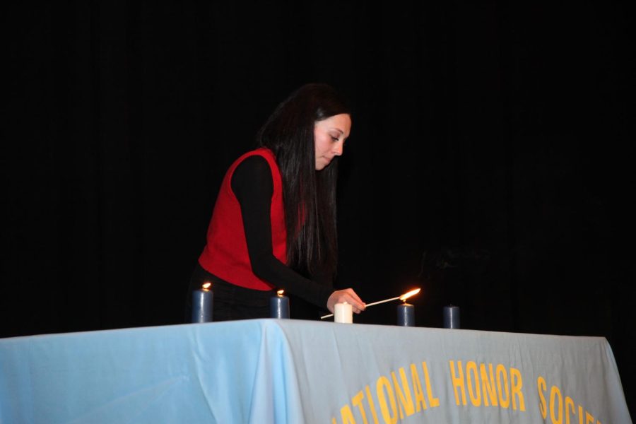 Officer Julianne Kellar (11) lights candles while explaining the pillars of National Honor Society. 