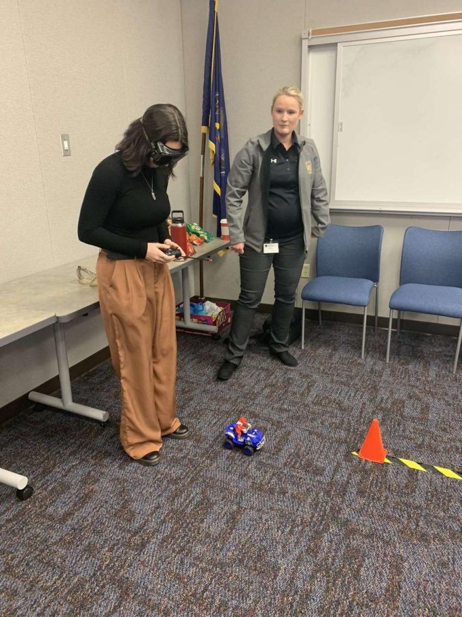 Elizabeth Long (12) tries to direct a toy car while wearing goggles simulating intoxication. 