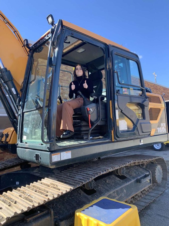 Elizabeth Long (12) poses for a picture in an excavator. 