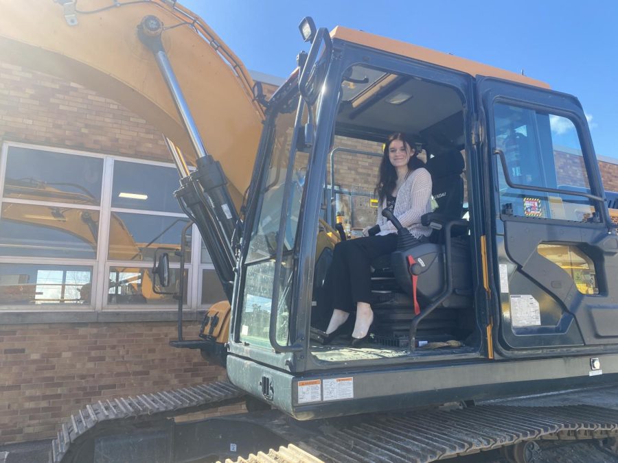 Genevieve Wills (12) poses for a picture in the excavator. 