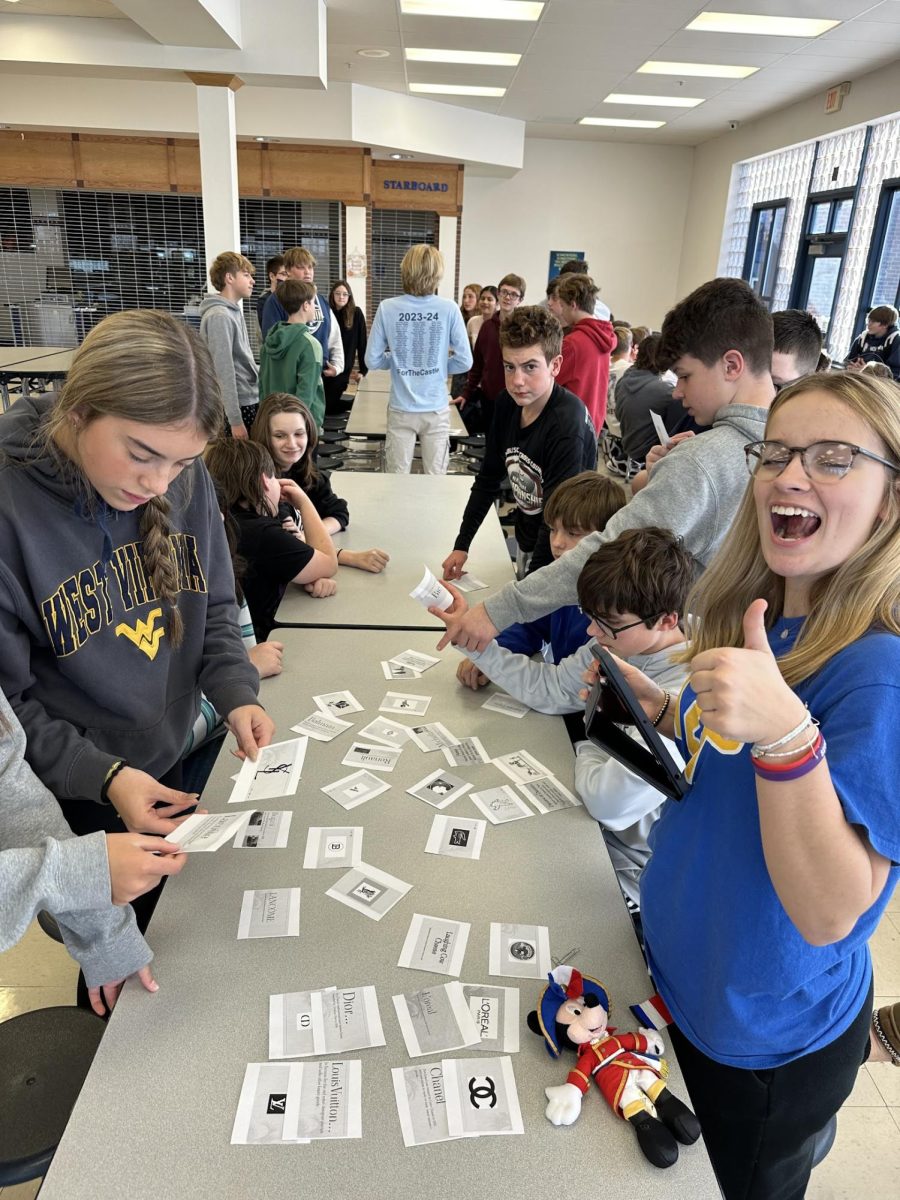 Norwin French club member Kailey Resnik helps eighth graders match French logos and brands. 