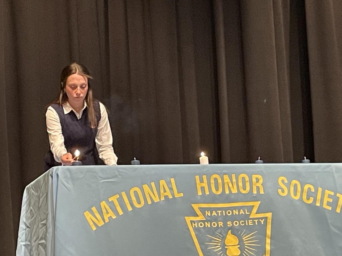 NHS officer Julianne Keller lights NHS candle at induction ceremony.