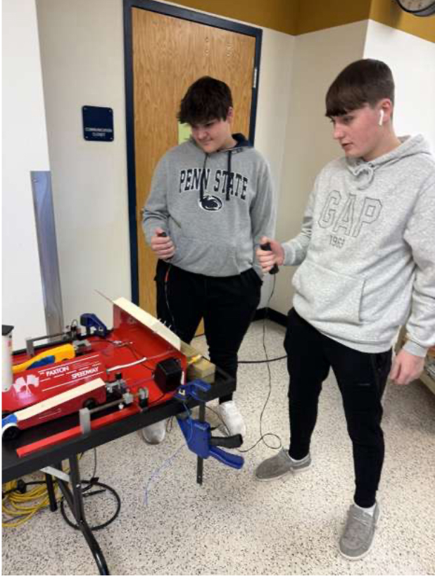 Students Owen McGuire and Zach McManus test out their CO2 cars on the runway outside his room.