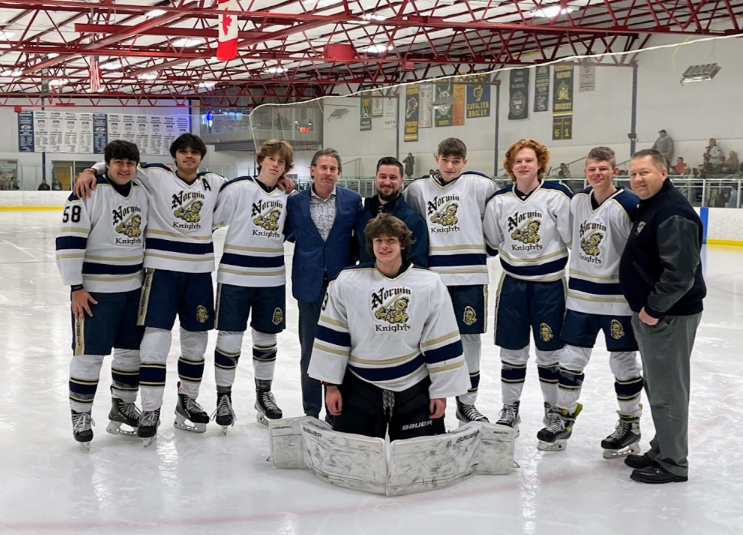 The senior hockey players smiling with their coaches.