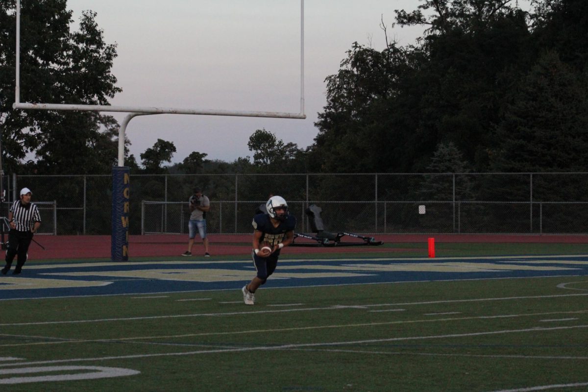 Jake Sincak catches the kickoff and begins to run the ball up the field.