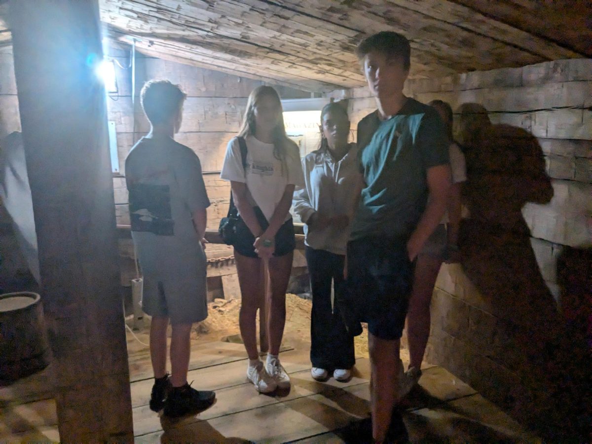 Juniors Landon Thomson, Jazzy Cherry, and Josh Bauer stand in the reconstructed underground gunpowder storehouse. 