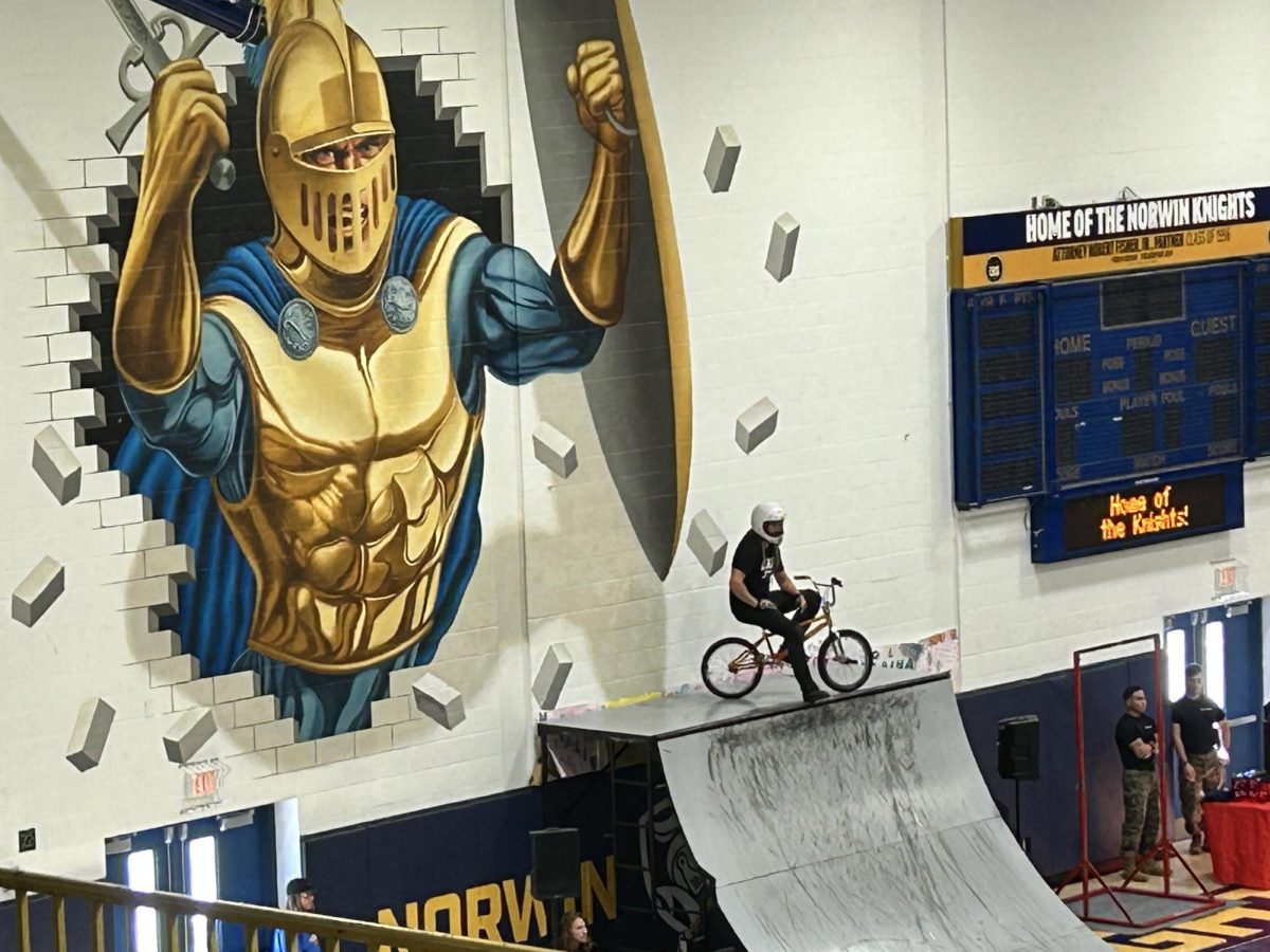 BMX performer sits upon a ramp before attempting a flip at Norwin’s No Hate Tour assembly.