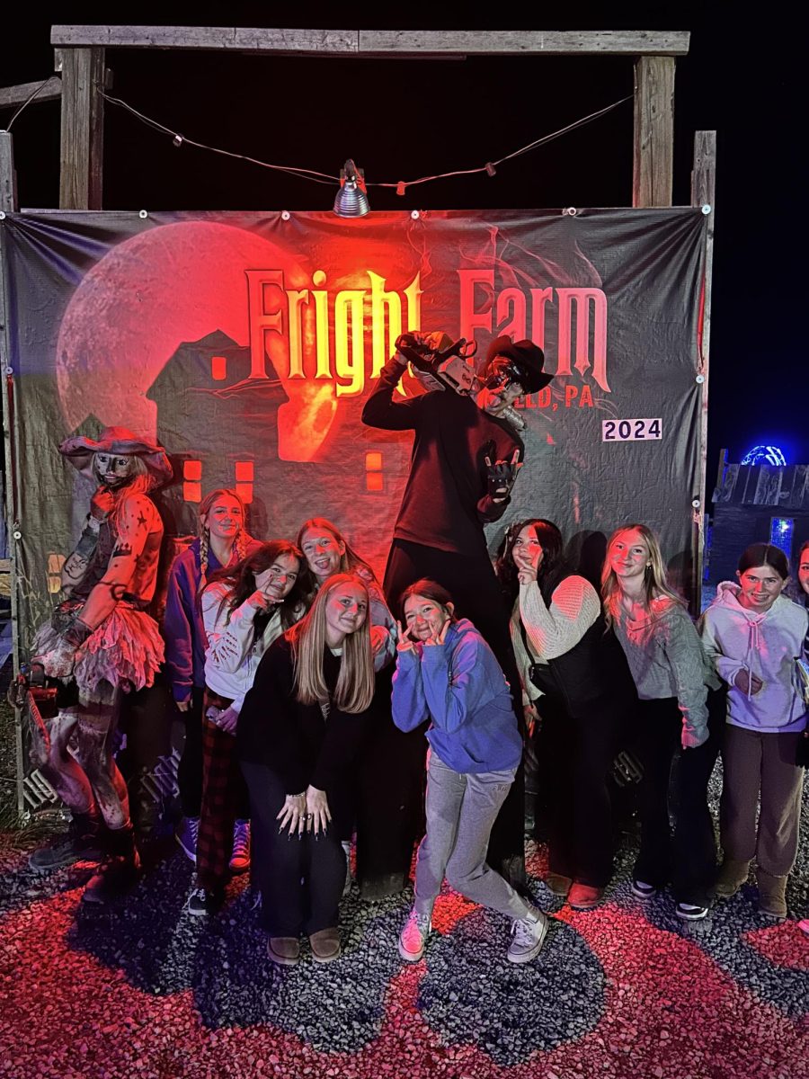 Freshmen ladies pose with a few "freaks" in front of the sign before touring the grounds.