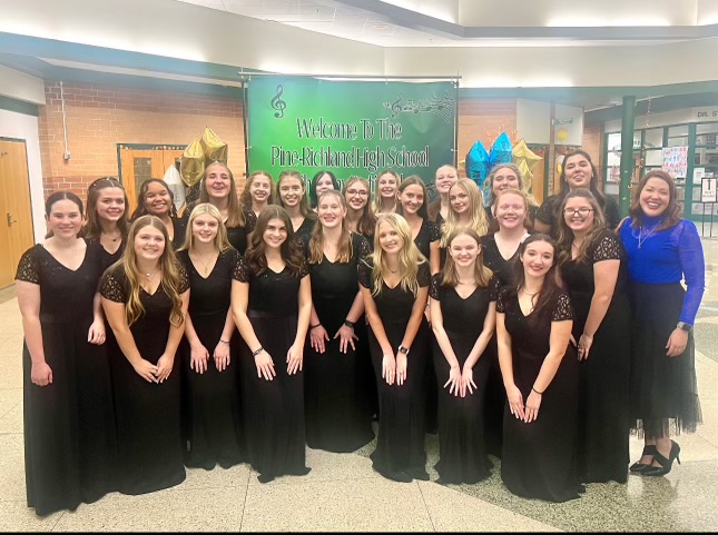 Bel Canto poses in front of the invitational sign before the event 