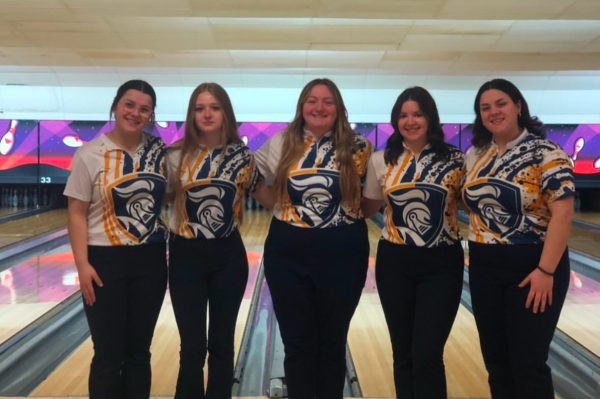 The girls bowlers pose for a picture in front of the lanes.