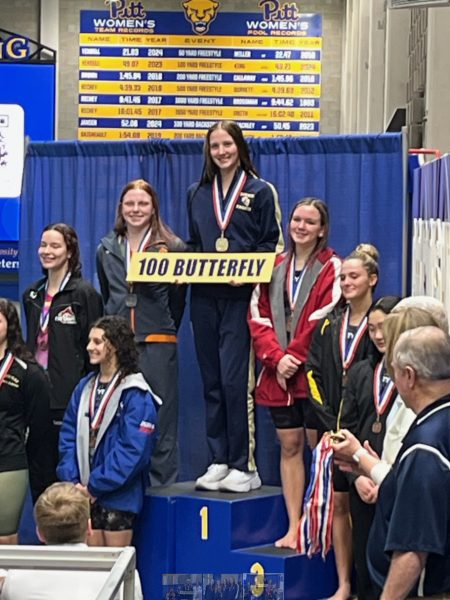 Sophomore Amber Klingensmith standing in 1st place for the 100 year butterfly on the podium. 