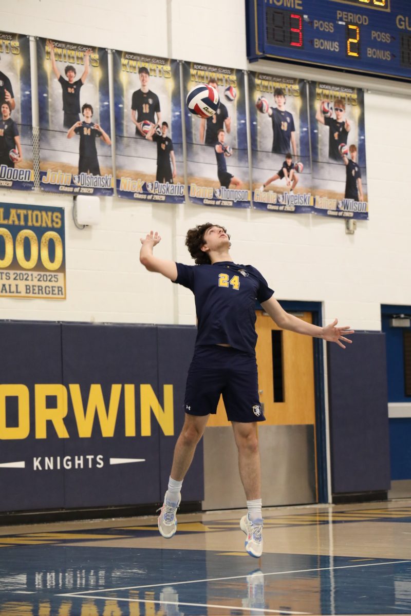 Jhon Olshanski(24) jumps serves for a point in a Section match. Olshanski finished his last year as middle blocker for the team.