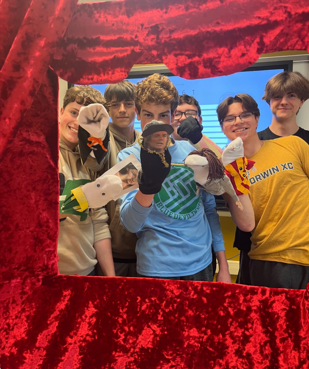 Students pose with their puppets, satisfied with their performance. 