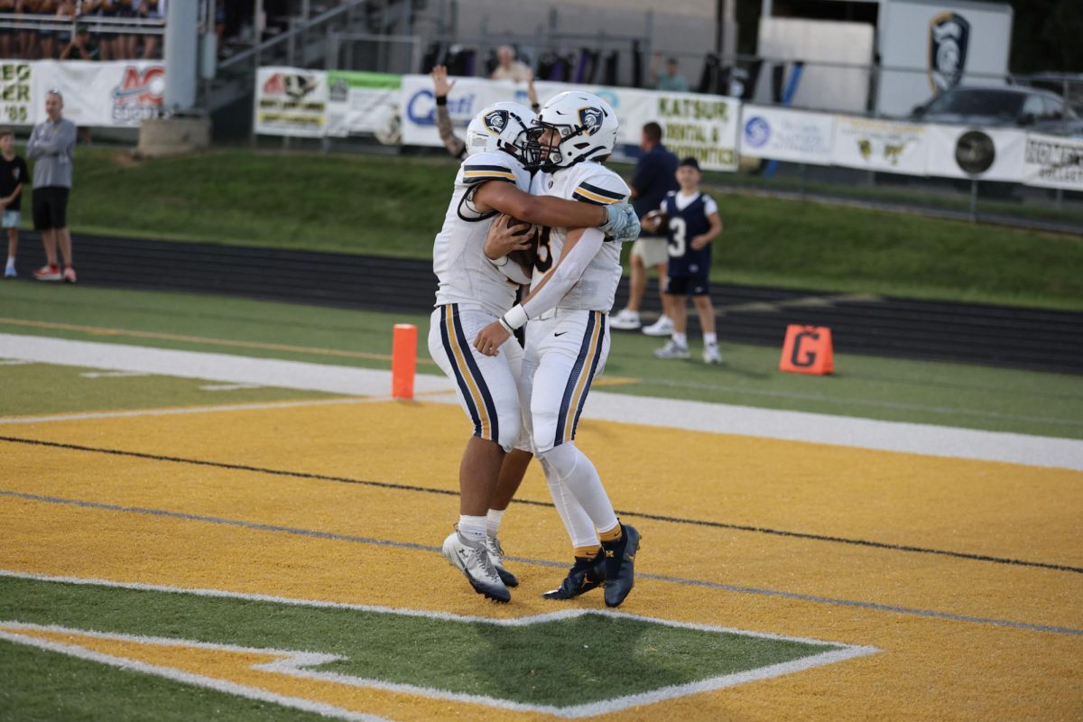 Tristyn Tavares and a teammate embrace after a touchdown