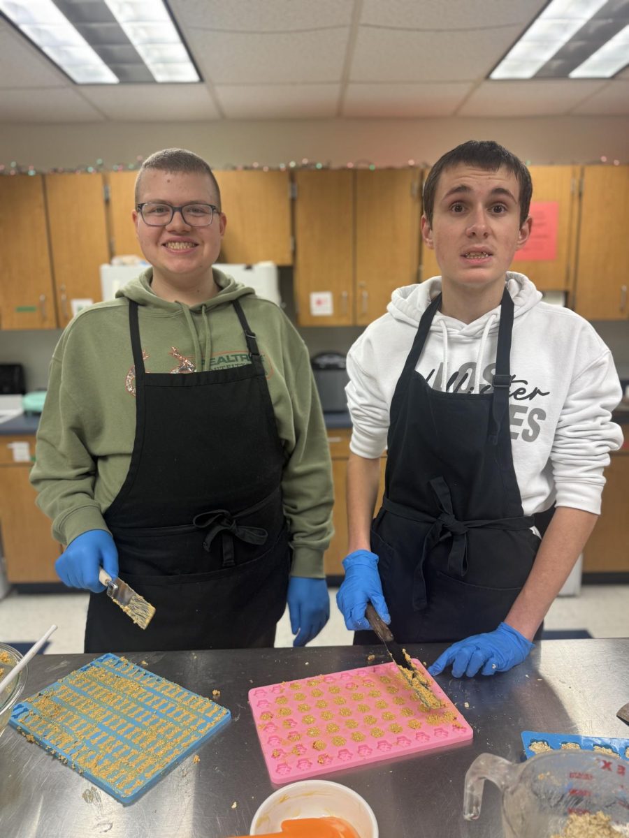 Timmy Langer (left) and Kayden Cichowicz (right) mold dog treats 