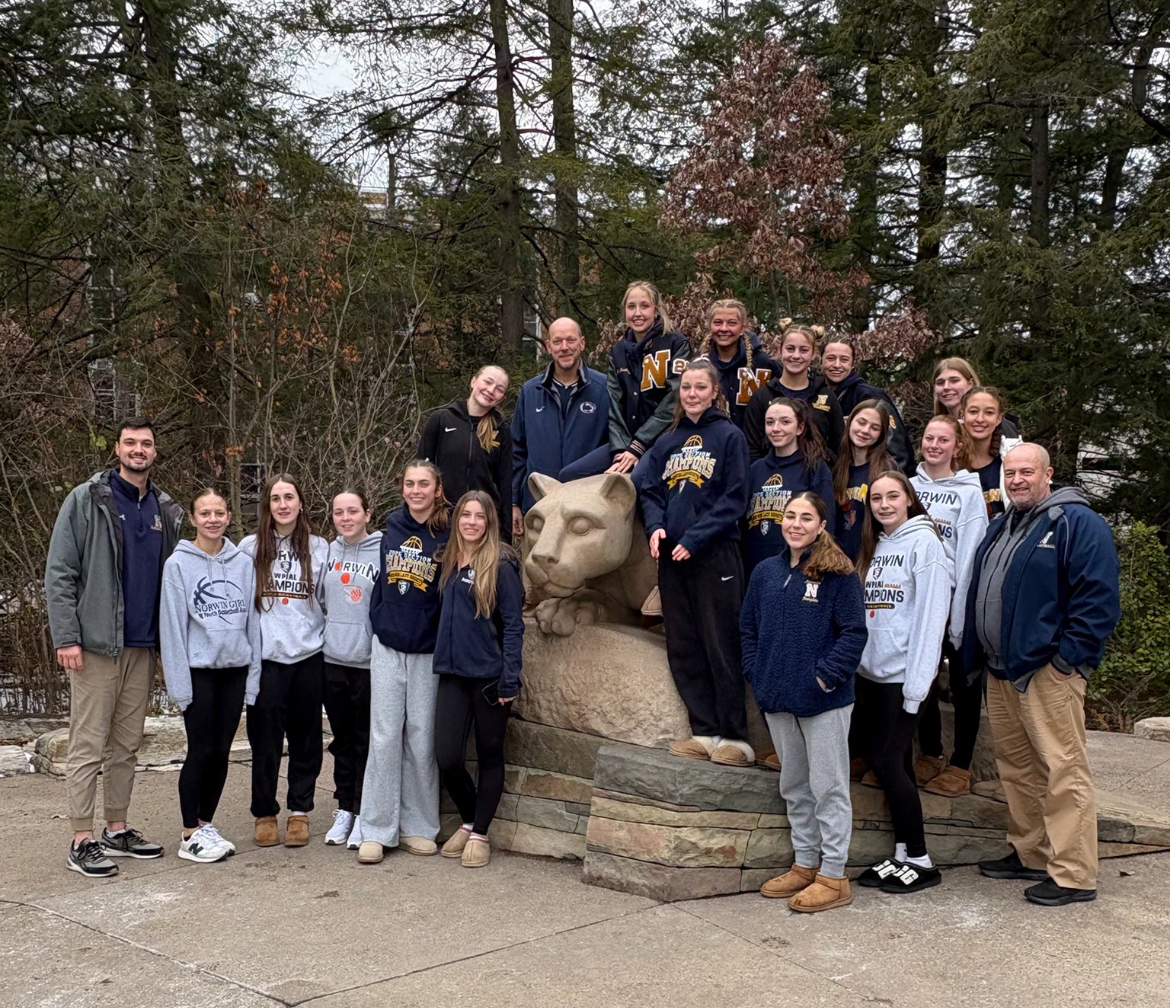 The girls basketball team takes a picture with the Penn State Nittany Lion.