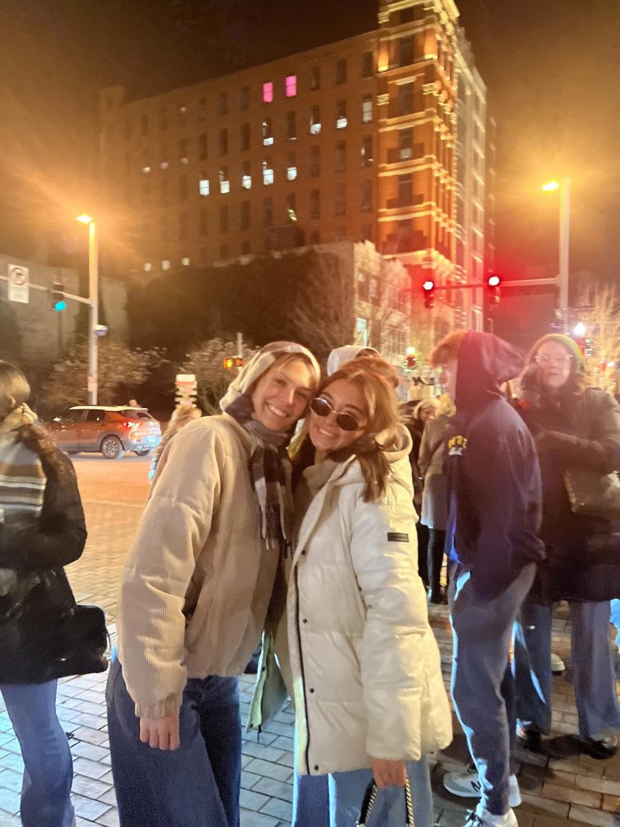 Cassandra Halazynski and Kalaina Phetsomphou pose outside the Christmas market.