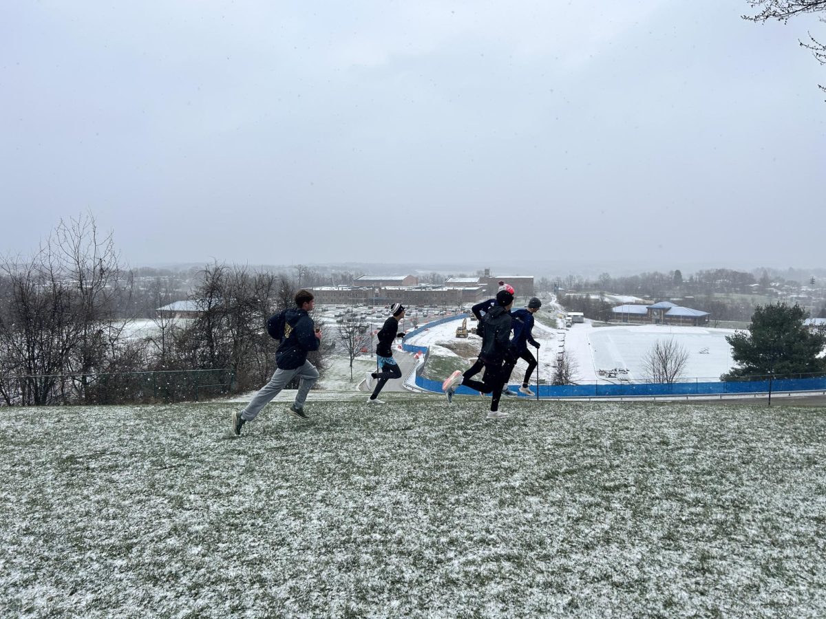Norwin distance runners run in snowy conditions atop Hillcrest hill.